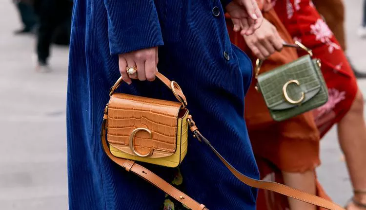 Девушка в синем пальто и маленькая бежевая сумочка
