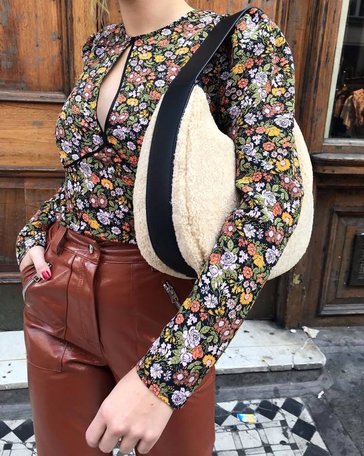 Девушка в кожаных брюках, блузка в цветочек и меховая сумочка