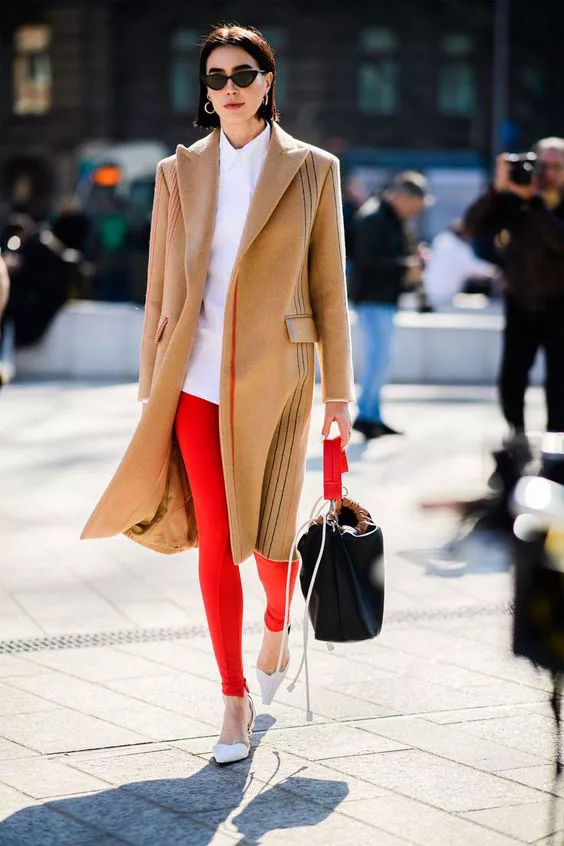 Девушка в красных леггинсах, белая рубашка и бежевое пальто