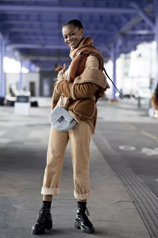 Девушка в светлых брюках, бежевый шарф и куртка, военные ботинки