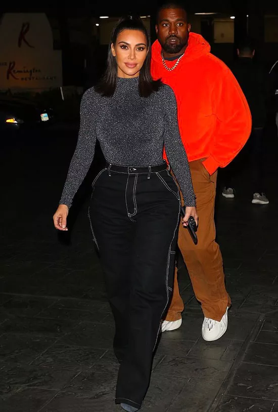 Ким Кардашьян в черных джинсах и серой водолазке