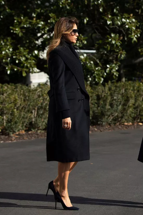 Мелания Трамп в черном пальто с широким ребристым воротником