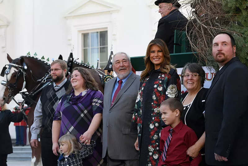 Мелания Трамп в цветочном пальто на совместном фото возле телеги с рождественской елкой
