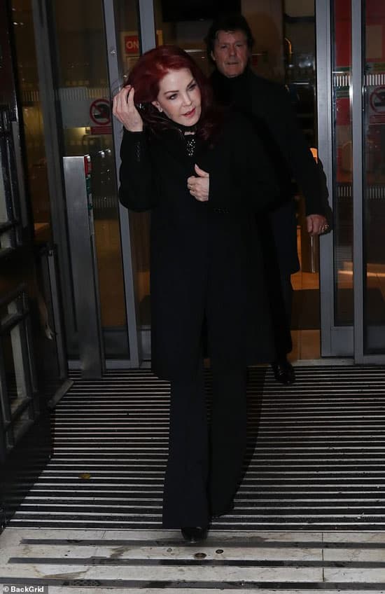 Присцилла Пресли в черном пальто и брюках клеш
