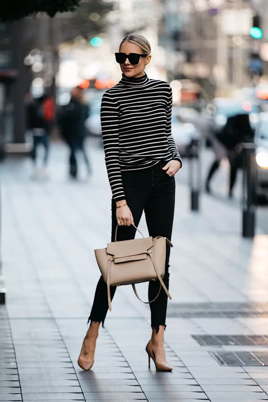 Девушка в черных джинсах, водолазка в полоску и бежевые туфли и сумочка