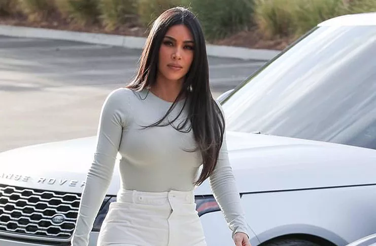 Ким Кардашьян подчеркивает свою стройную талию в сером боди и белых брюках
