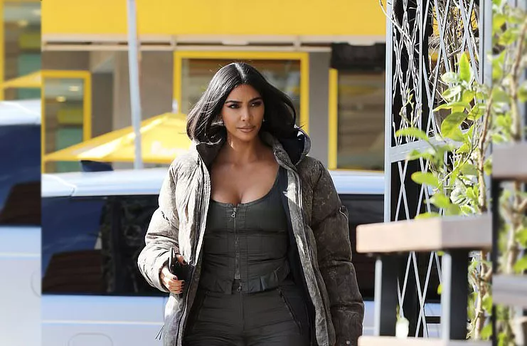 Ким Кардашьян в монохромном образе: спортивные брюки дополняются ботильонами и пуховиком