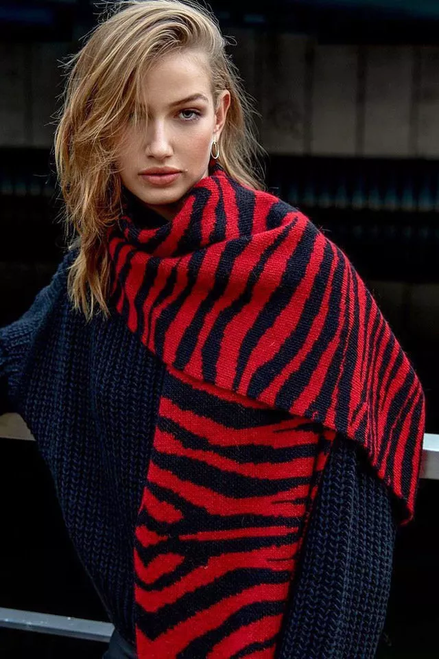 Девушка в черном свитере овесрайз и красный шарф