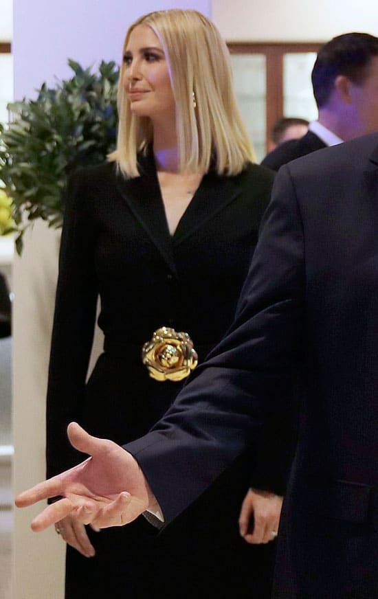 Иванка Трамп в длинном черном пальто с золотым цветком на поясе