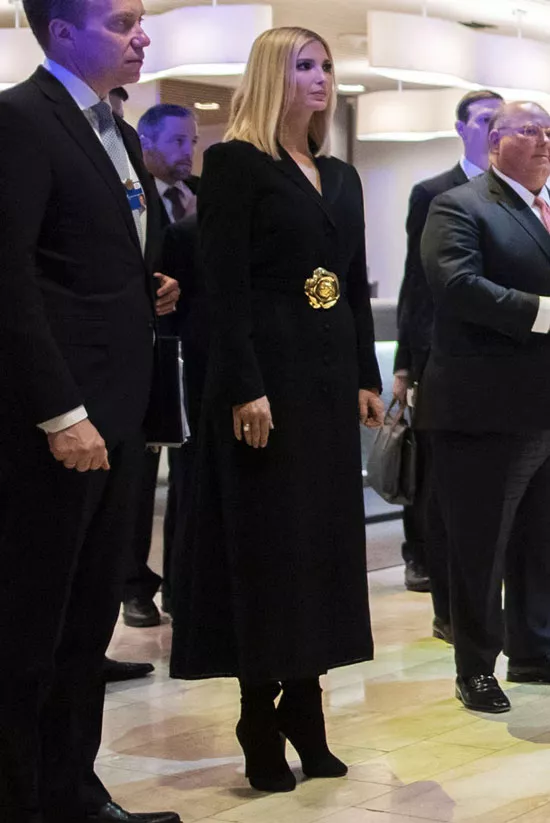 Иванка Трамп в длинном черном пальто с золотым цветком на поясе и сапогах на шпильке