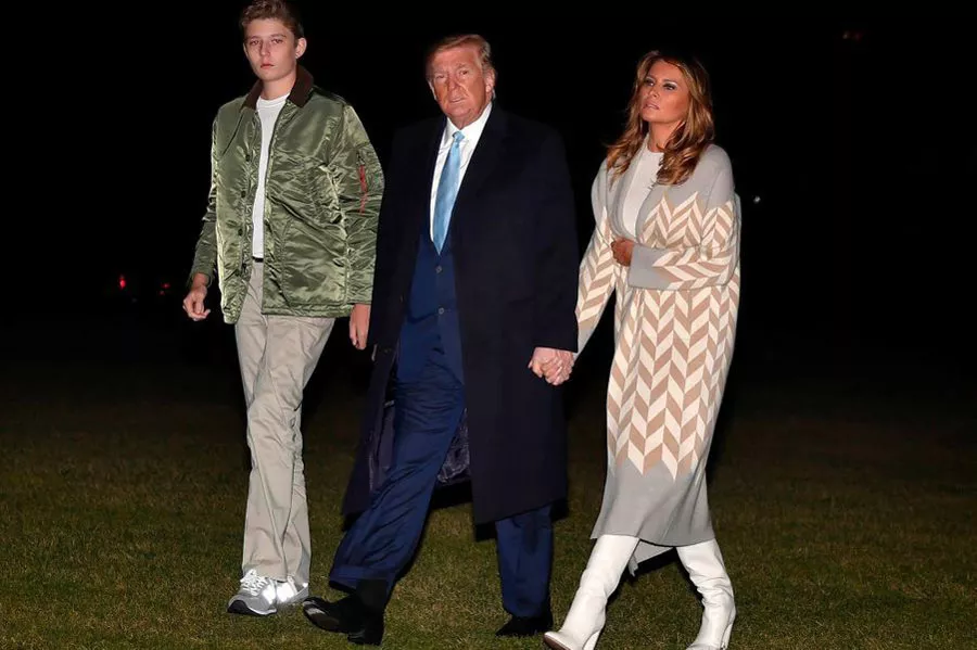Мелания Трамп в белых сапогах и светлом пальто с принтом