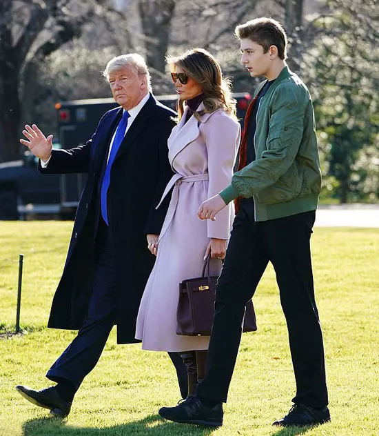 Мелания Трамп в сиреневом пальто и темно-красных сапогах