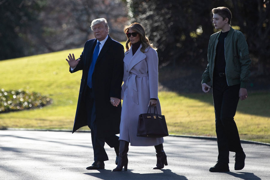 Мелания Трамп в сиреневом пальто, сапогах трубах и водолазке