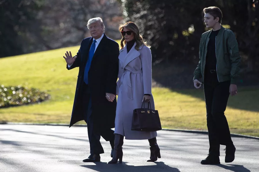 Мелания Трамп в сиреневом пальто, сапогах трубах и водолазке