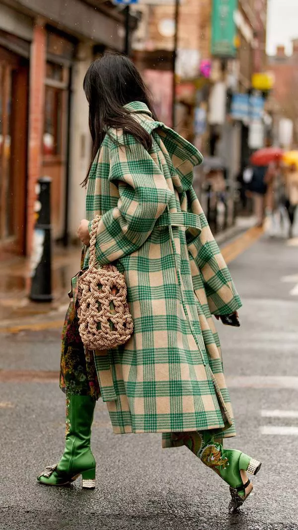 Девушка в бежево-зеленом пальто в клетку, необычные зеленые сапоги и сумка