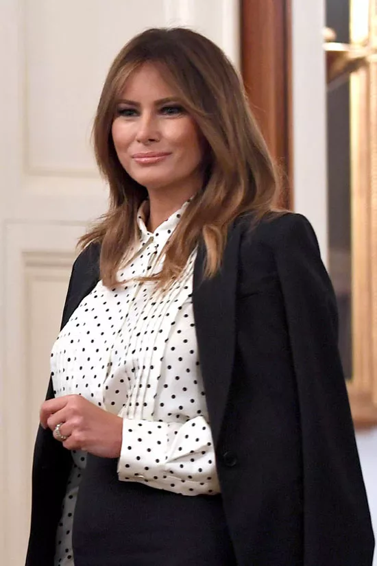 Мелания Трамп в белой блузке в горошек и костюме с юбкой
