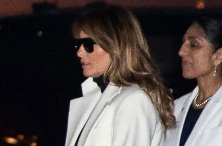 Мелания Трамп в джинсах скинни, белом пальто и рокерских ботинках с пряжками