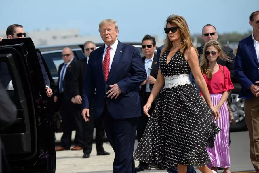 Мелания Трамп в черном платье с белым поясом и очках