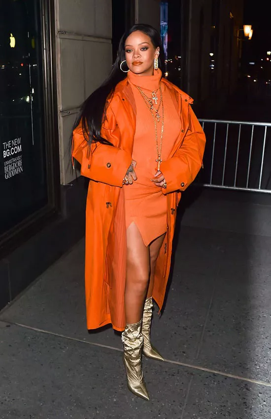 Рианна в оранжевом платье, плаще и золотых сапогах