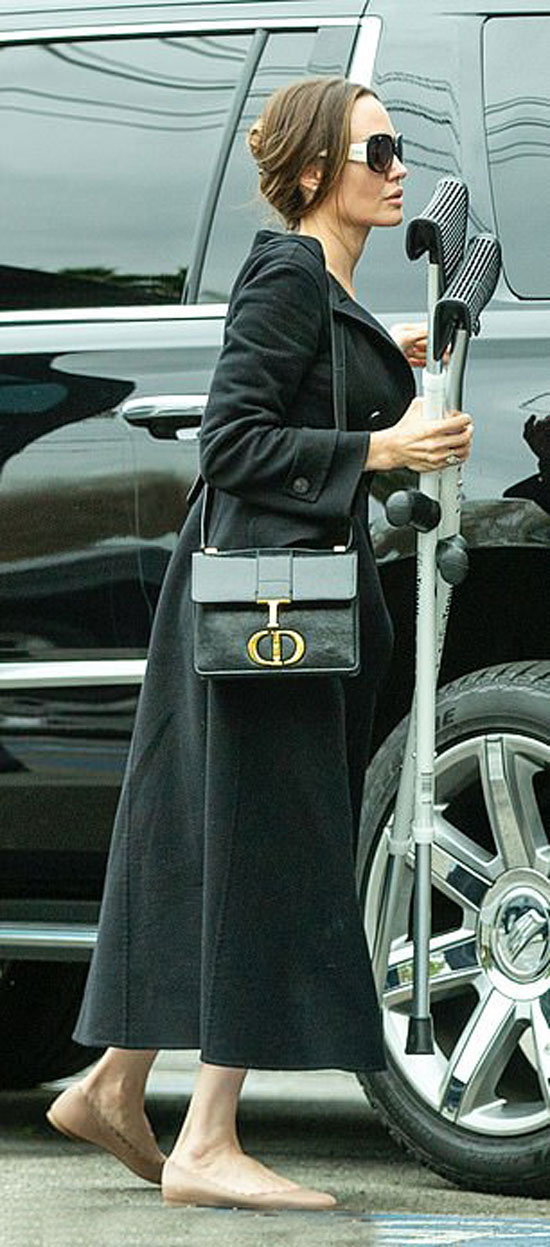 Анджелина Джоли в платье, черном пальто и балетках