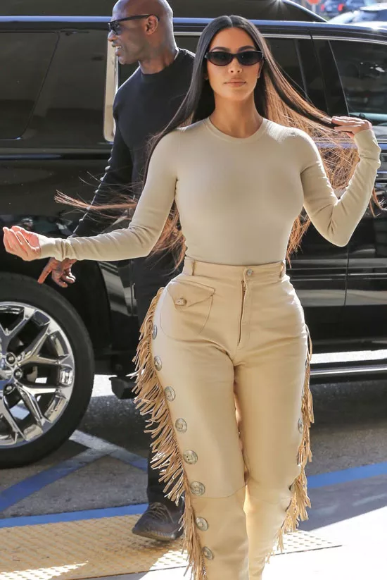 Ким Кардашьян в бежевом боди, ковбойских брюках и солнцезащитных очках