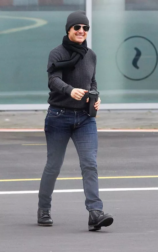 Том Круз в сером свитере, темных джинсах и шапке