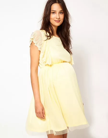 Девушка в светло-желтом, коротком платье для беременных