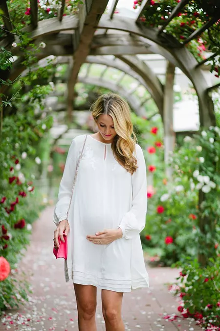 Девушка в свободном, белом платье для беременных
