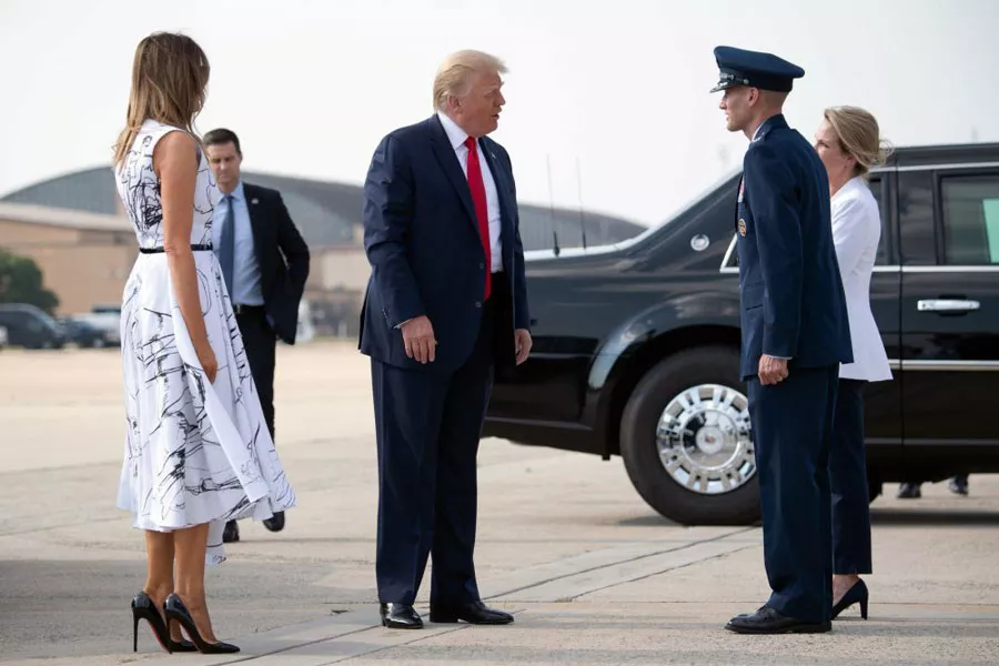 Мелания Трамп в белом платье миди и черным ремешком