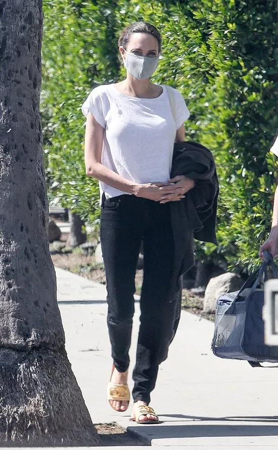 Анджелина Джоли в белой футболке и черных джинсах
