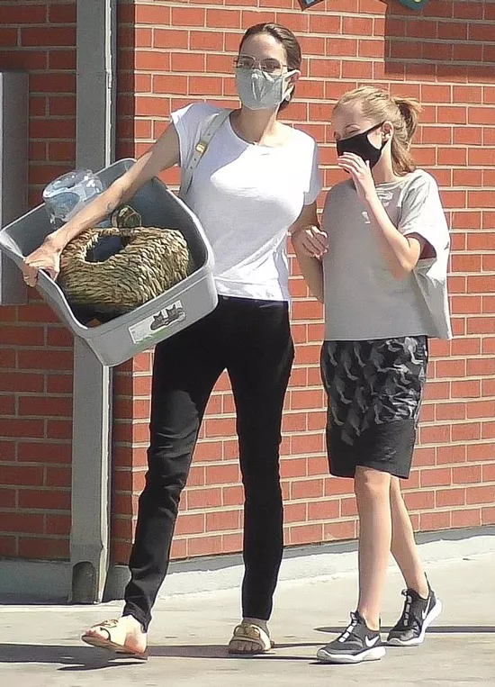 Анджелина Джоли в белой футболке и золотистых шлепанцах