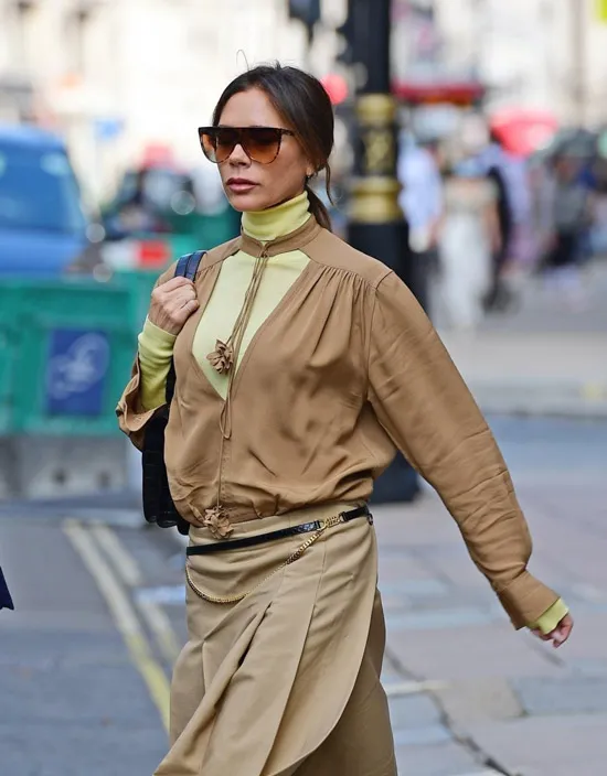 Виктория Бекхэм в неоновой водолазке и коричневой блузе