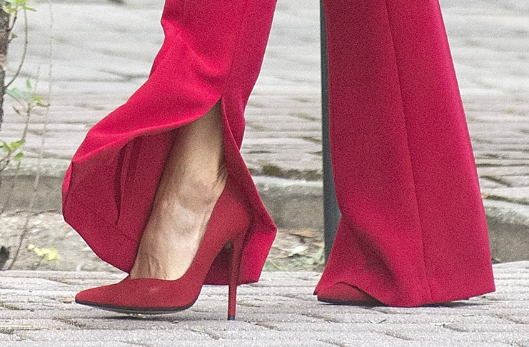 Королева Испании в красном костюме с разрезами на брюках выглядит выше чем обычно