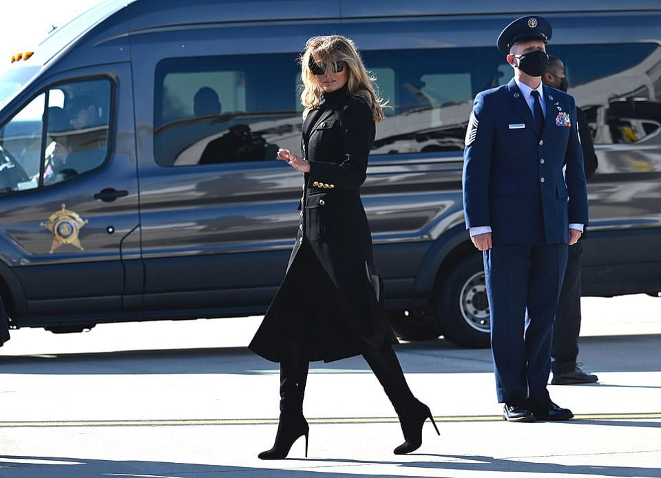 Мелания Трамп в пальто и модных сапогах выше колена