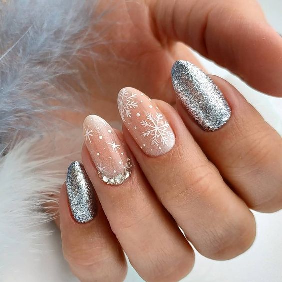 Маникюр с серебристыми блестками и снежинками на овальных ногтях