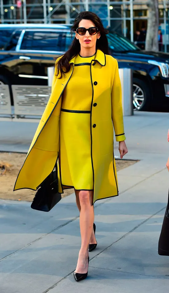 Амаль Клуни в желтом платье выше колен и ярком пальто, черные туфли лодочки