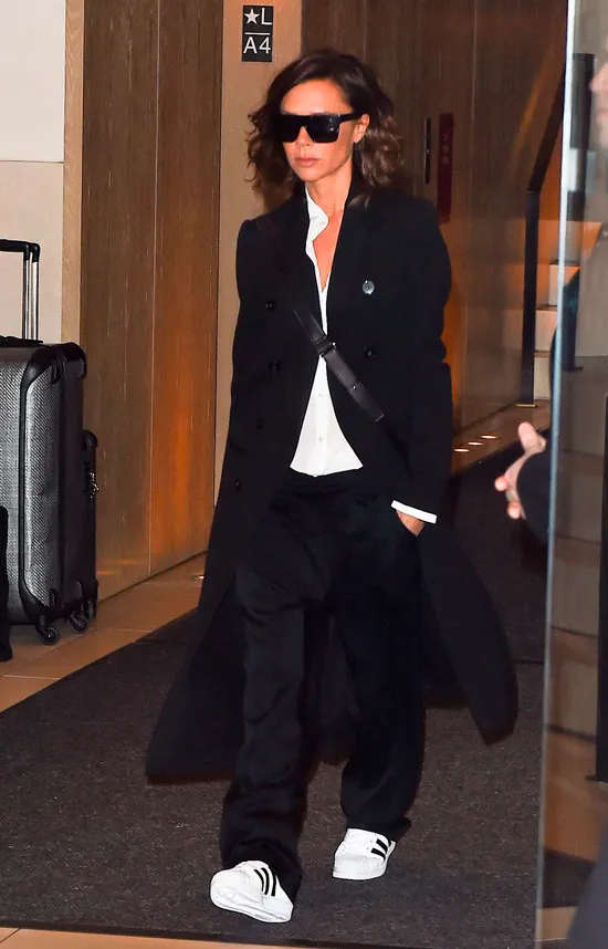 Виктория Бекхэм в черных брюках, белая рубашка и черное пальто