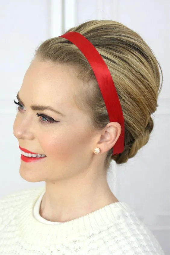 Девушка со светлыми волосами аккуратно собранными сзади с красной повязкой