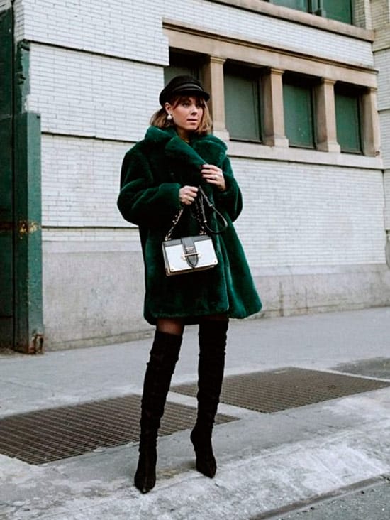 Девушка в зеленом пальто тедди, сапоги ботфорты и черная кепка
