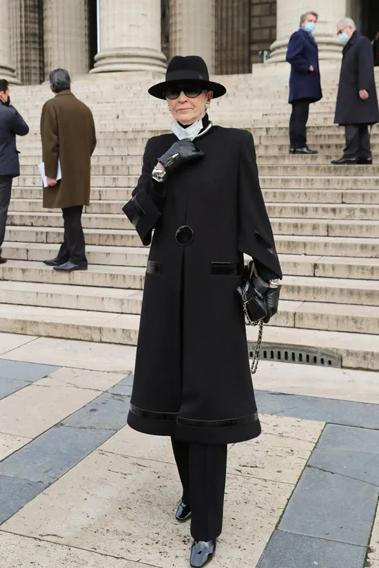 Maryse Gaspard в черном пальто и шляпе