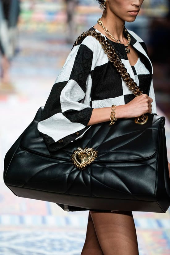 Модель Dolce & Gabbana в черно-белом мини платье с большой кожаной сумкой на цепях