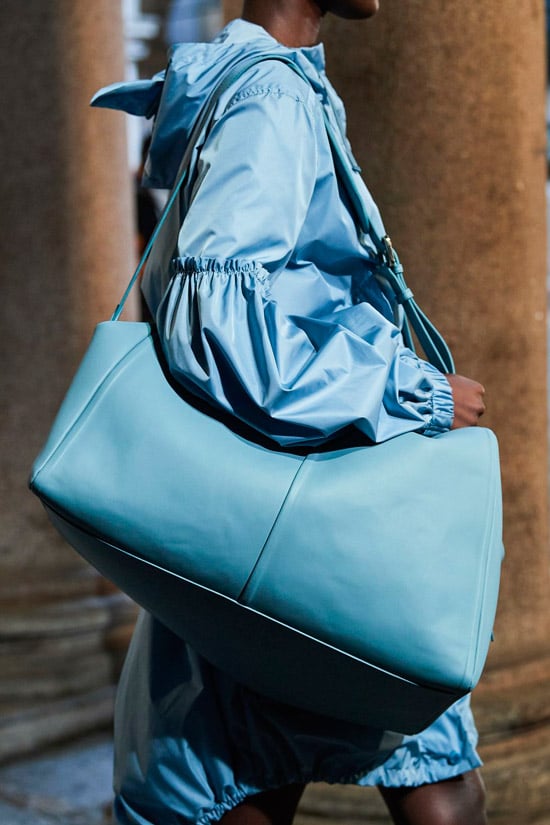 Модель Max Mara в голубом плаще и с объемной голубой сумкой