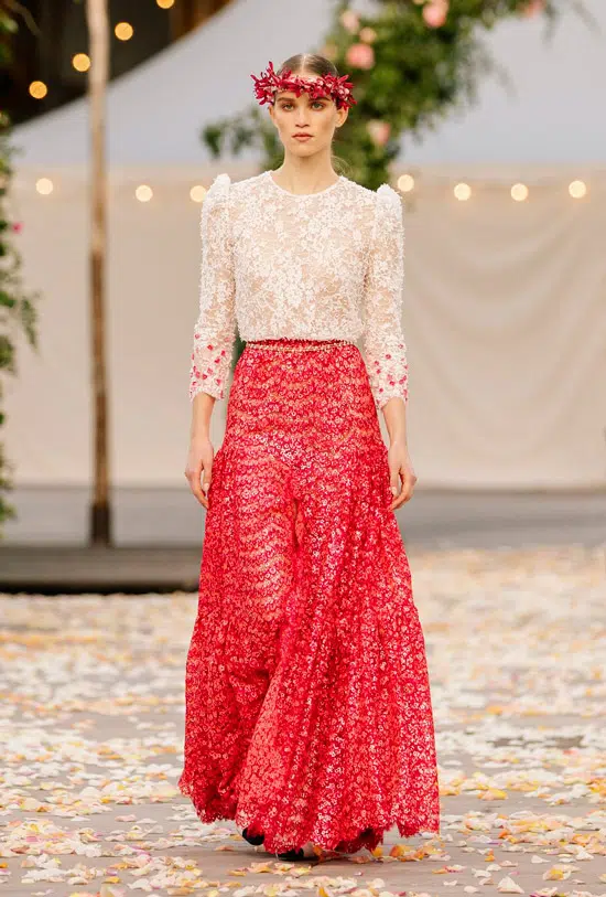 Модель в длинной красной юбке с цветочным принтом и кружевная блузка