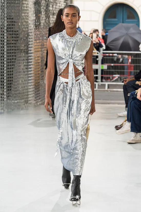 Модель в серебристом блестящем платье от Paco Rabanne