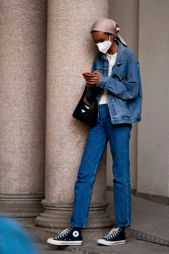 Модель в синих джинсах, куртка оверсайз и простые кеды