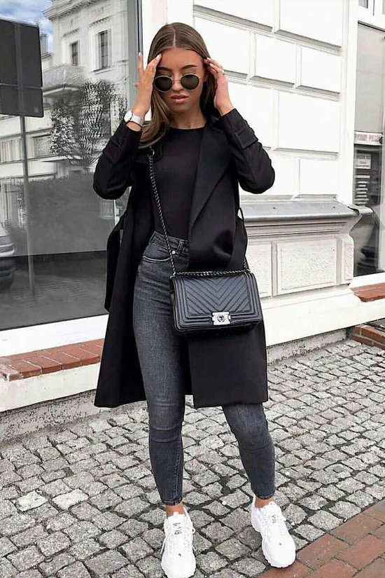 Девушка в черном пальто и кроссовках