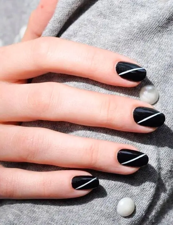 Черный глянцевый маникюр на овальных ногтях с простой белой полосой