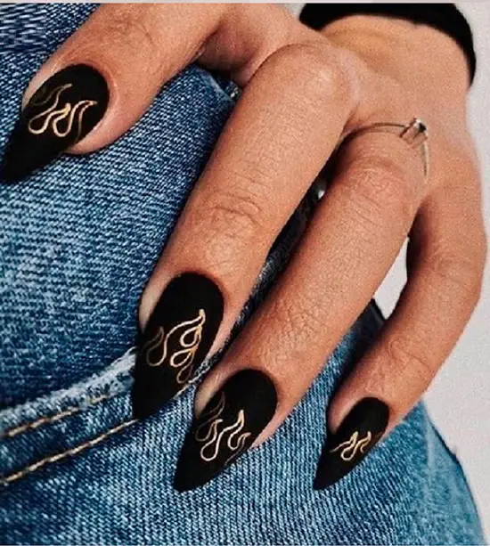 Черный матовый маникюр с золотыми узорами на длинных овальных ногтях