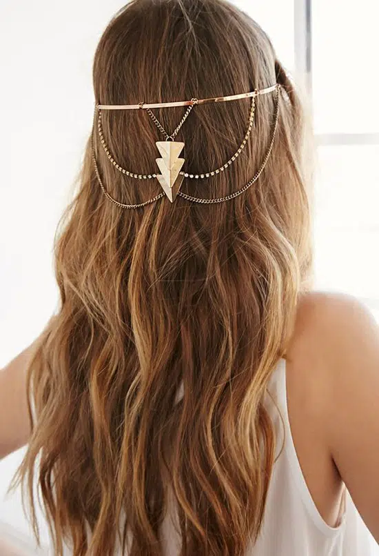 Девушка с ухоженными длинными волосами, украшенные золотыми цепочками