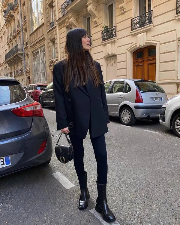 Девушка в черном пиджаке оверсайз, лосины и темные ботинки на толстом каблуке